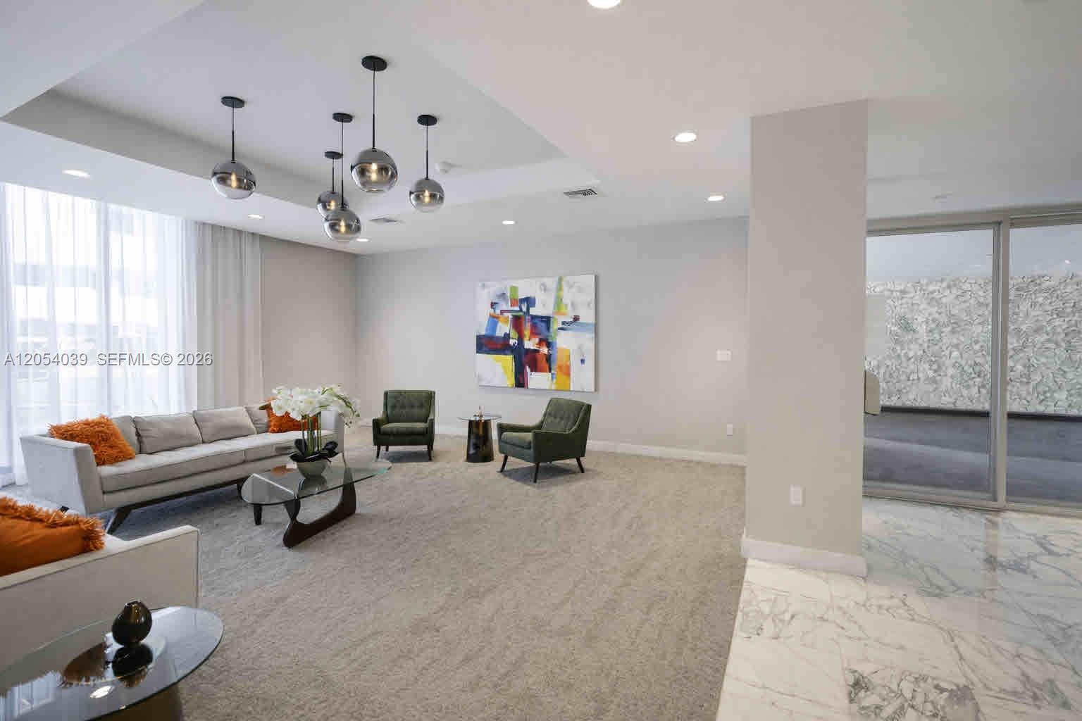 A modern living room features a gray sofa, two green armchairs, and globe pendant lights — 9225 Collins Ave # 505, Surfside FL 33154, SURFSIDE, FL
