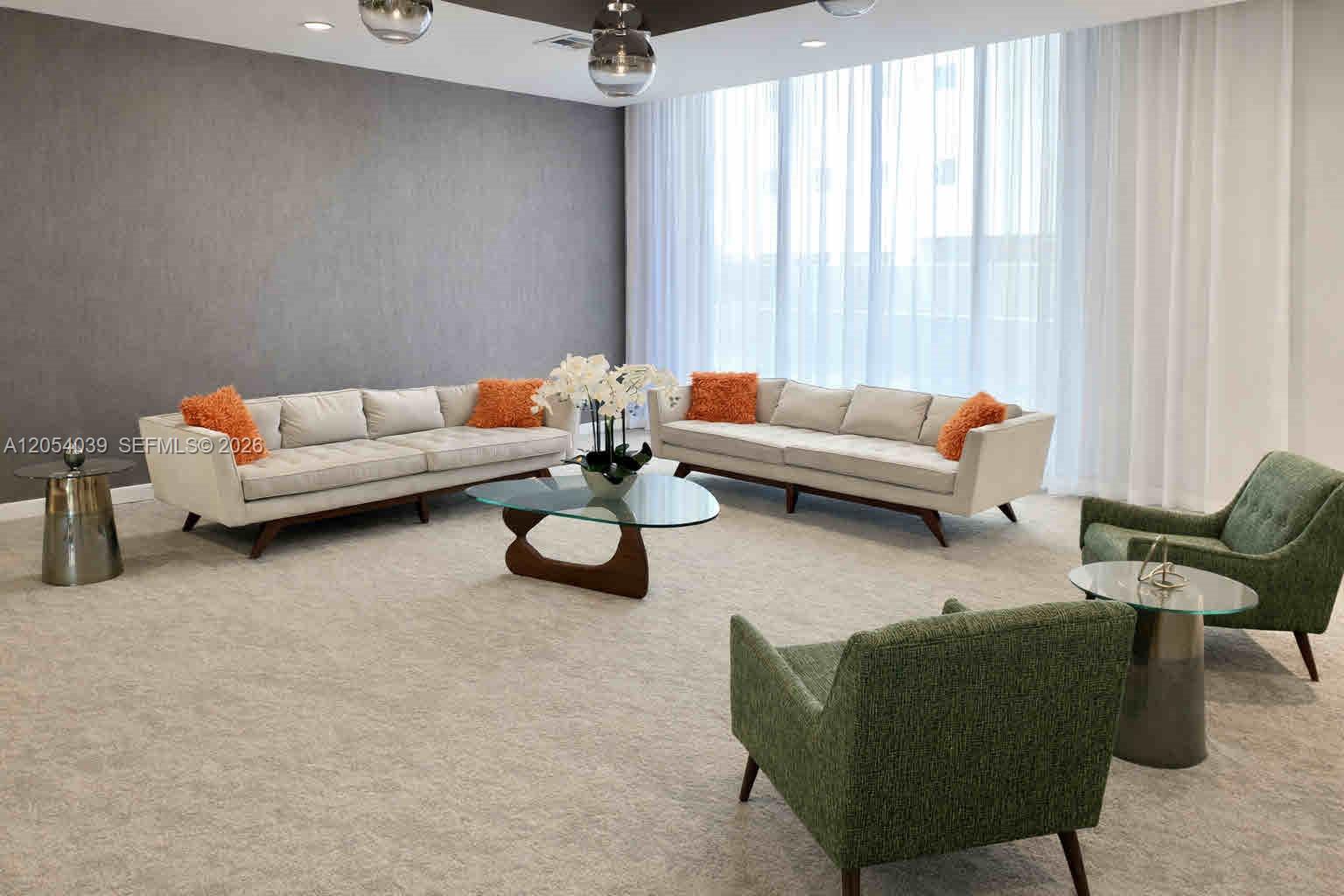 A modern living room features two beige sofas, two green armchairs, and a glass coffee table — 9225 Collins Ave # 505, Surfside FL 33154, SURFSIDE, FL