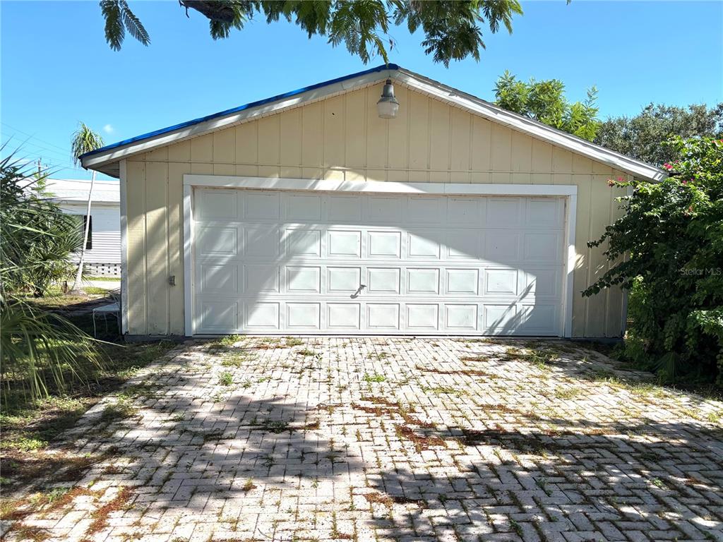 A detached garage with a white sectional door and a paved driveway — 30 HATCHETT CREEK ROAD, VENICE, FL