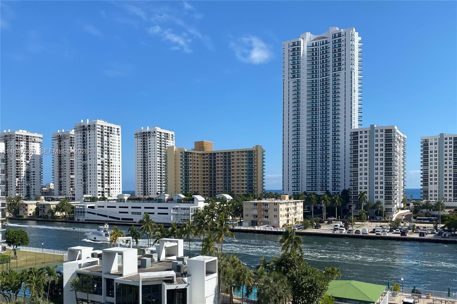 An exterior view of a waterway lined with high-rise apartment buildings and palm trees — 800 Parkview Dr # 708, Hallandale Beach FL 33009, HALLANDALE BEACH, FL