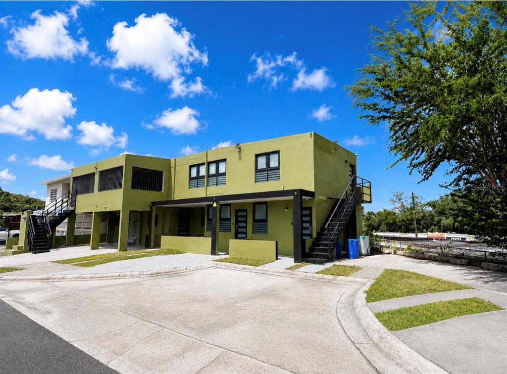 A two-story green apartment building with black metal staircases and a concrete parking area — 84 ST.  Num 98-1 URB BRISAS DE SIERRA BAYAMON APT. #4, BAYAMON, PR