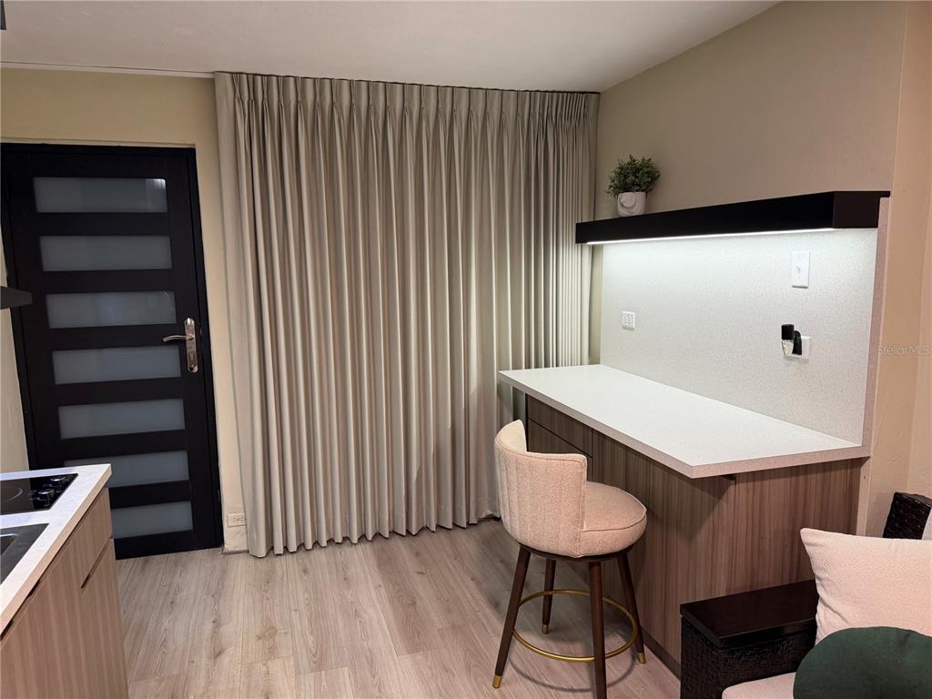 A room features light wood flooring, floor-to-ceiling curtains, a modern black door, and a built-in desk — 84 ST.  Num 98-1 URB BRISAS DE SIERRA BAYAMON APT. #4, BAYAMON, PR
