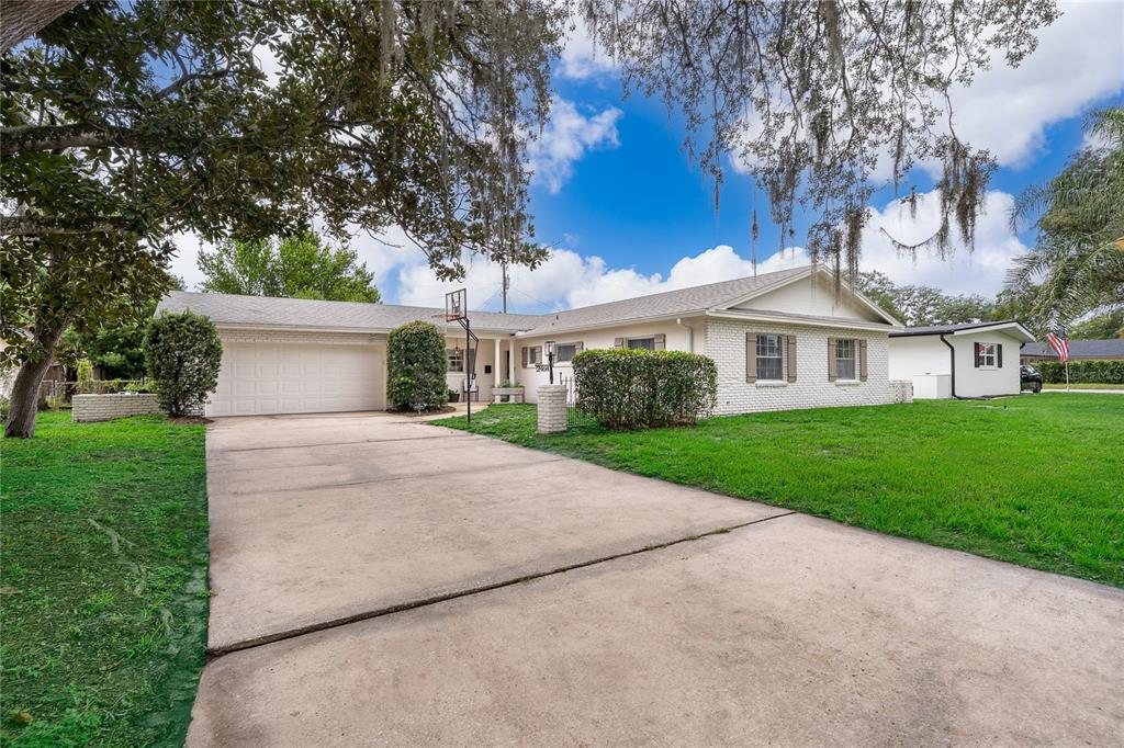 A single-story white brick house with a concrete driveway and a basketball hoop — 2464 HUNTERFIELD ROAD, MAITLAND, FL