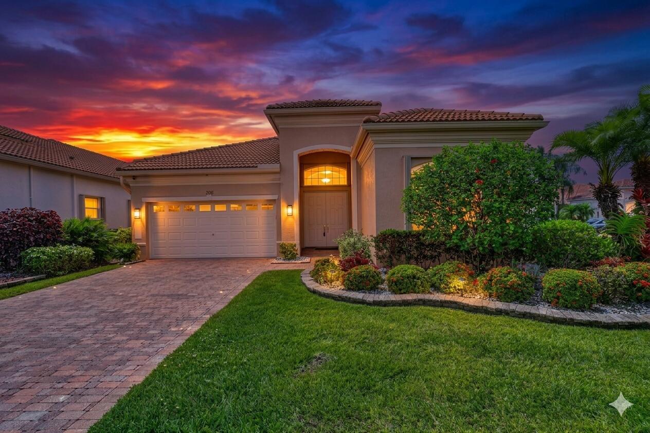 A single-story stucco house with a tiled roof, brick driveway, and landscaped front yard at sunset — 7196 Lorenzo Lane, Delray Beach FL 33446, DELRAY BEACH, FL