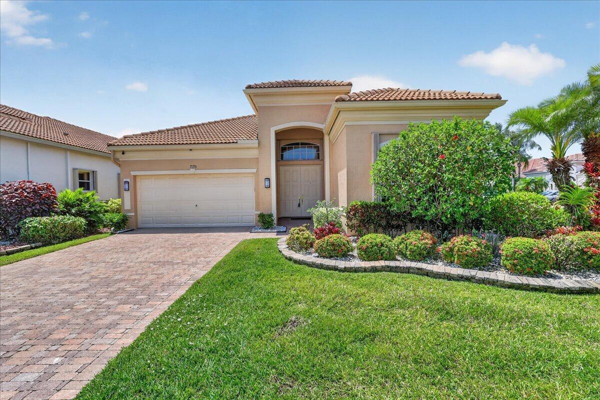 A single-story house with a beige stucco exterior, a tile roof, and a paved driveway — 7196 Lorenzo Lane, Delray Beach FL 33446, DELRAY BEACH, FL