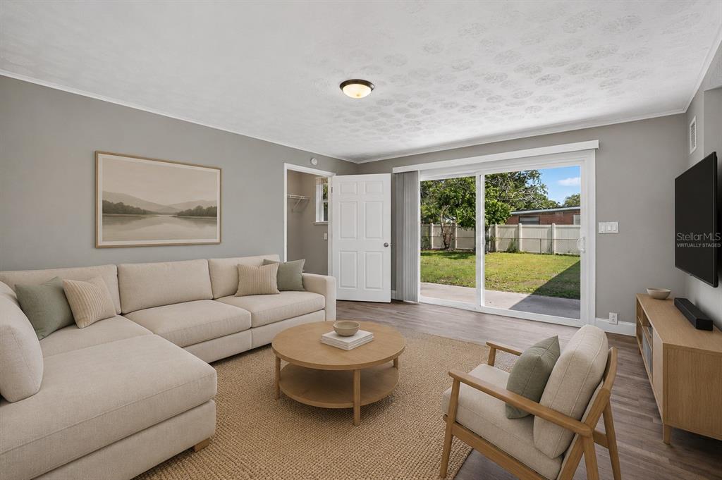 A living room features a sectional sofa, a round coffee table, and sliding glass doors — 3734 BARMER DRIVE, JACKSONVILLE, FL