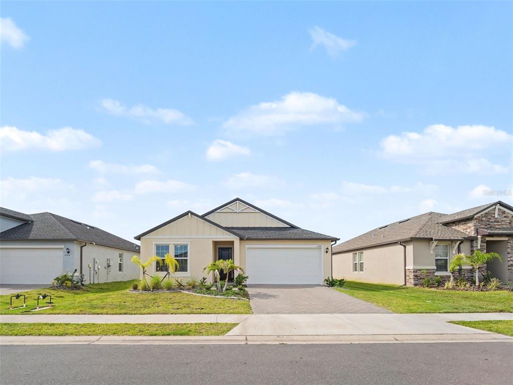 A single-story suburban house with a two-car garage and a landscaped front yard — 11704 74TH CIR E, PALMETTO, FL