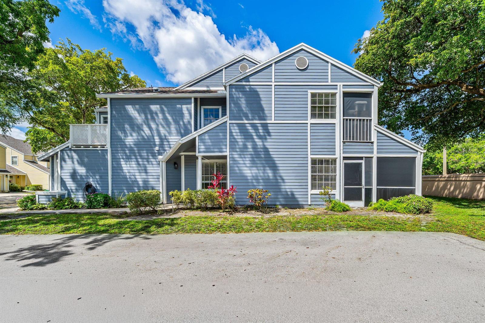 A two-story blue-sided residential building with a screened-in porch and surrounding trees — 5331 Buckhead Circle # 1030, Boca Raton FL 33486, BOCA RATON, FL