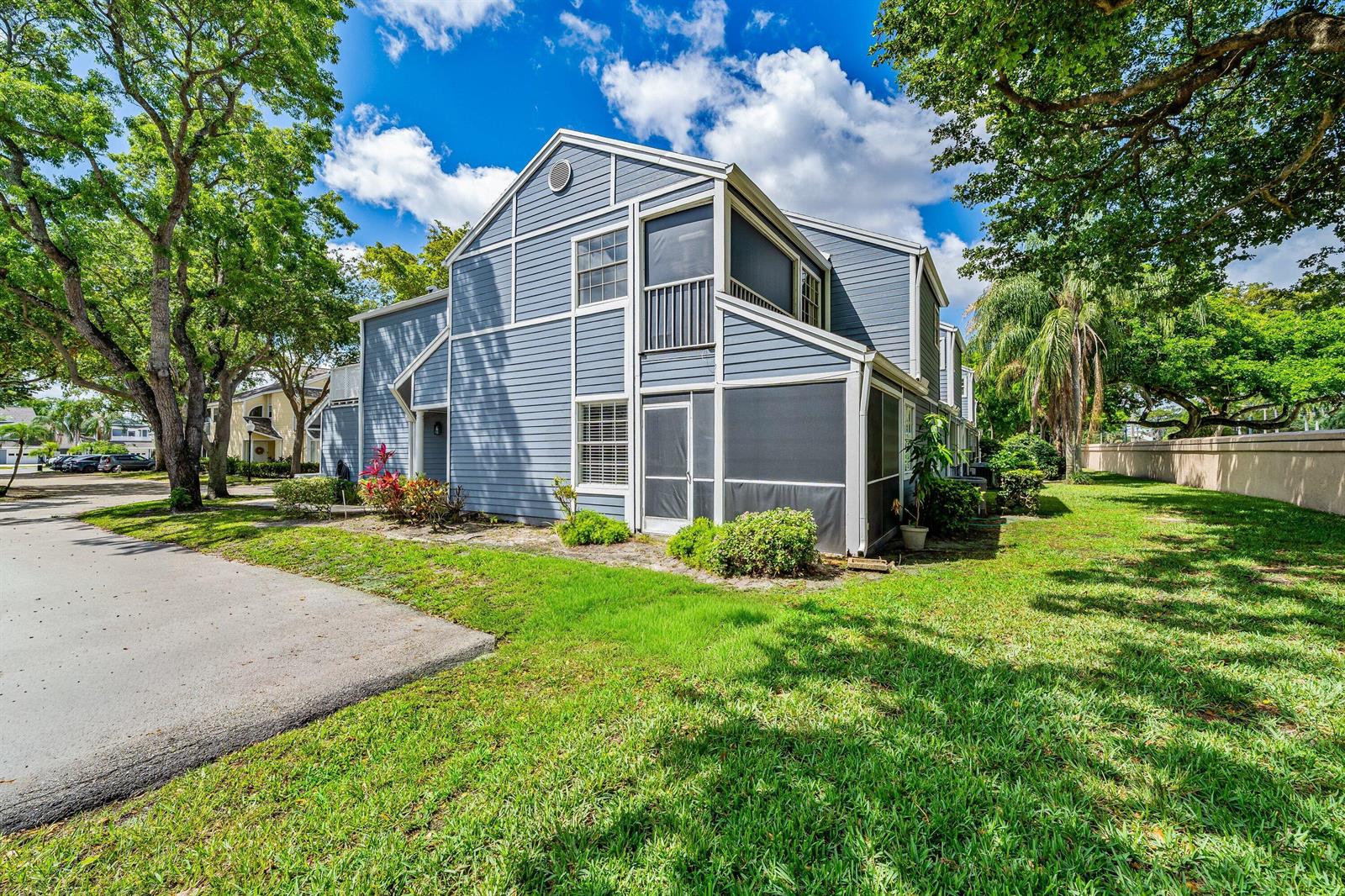 A blue two-story townhouse with a screened-in porch and balcony sits on a grassy lawn — 5331 Buckhead Circle # 1030, Boca Raton FL 33486, BOCA RATON, FL