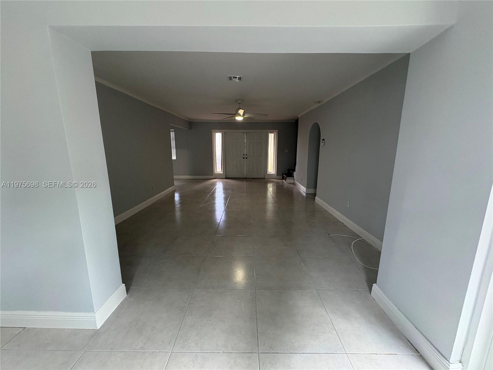 An empty room with light gray walls, large floor tiles, and a double front door — 3600 SW 32nd Ave, West Park FL 33023, WEST PARK, FL