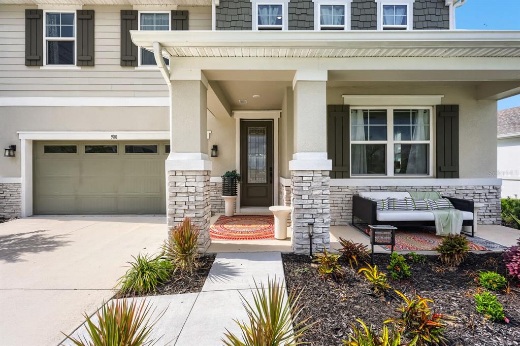 A front exterior view of a house featuring a stone-accented porch and a garage — 900 GRIFFON AVENUE, LAKE ALFRED, FL