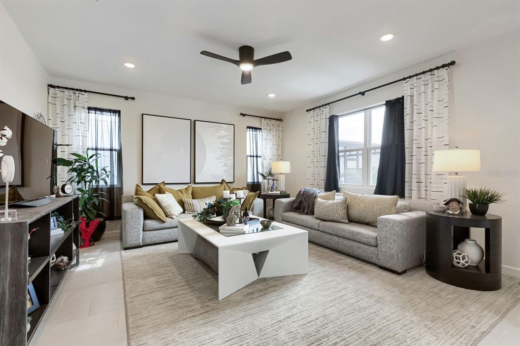 A living room features two gray sofas, a white coffee table, and patterned curtains — 900 GRIFFON AVENUE, LAKE ALFRED, FL