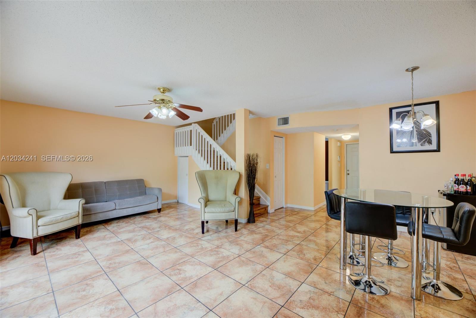 A living and dining area features tile flooring, a staircase, and a ceiling fan — 7661 NW 38th Ct, Sunrise FL 33351, SUNRISE, FL