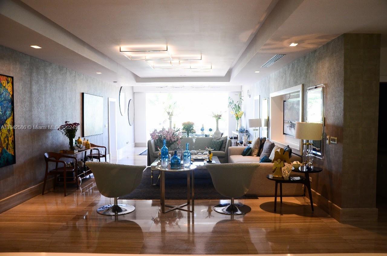 A modern living room features a neutral sofa, two swivel chairs, and recessed ceiling lighting — . Condominio Fundadores Marina Cap Cana, FL, FL