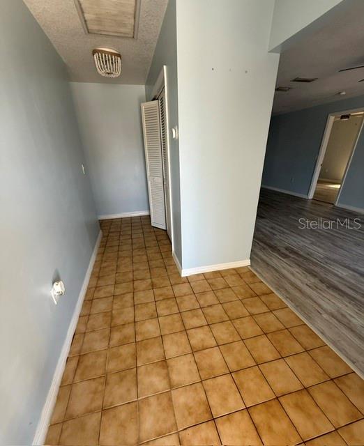 A tiled hallway leads to a doorway and an adjacent room with wood-look flooring — 465 E SEMINOLE DRIVE, VENICE, FL
