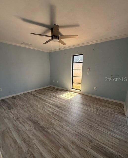 An empty bedroom features light blue walls, wood-look flooring, and a ceiling fan — 465 E SEMINOLE DRIVE, VENICE, FL