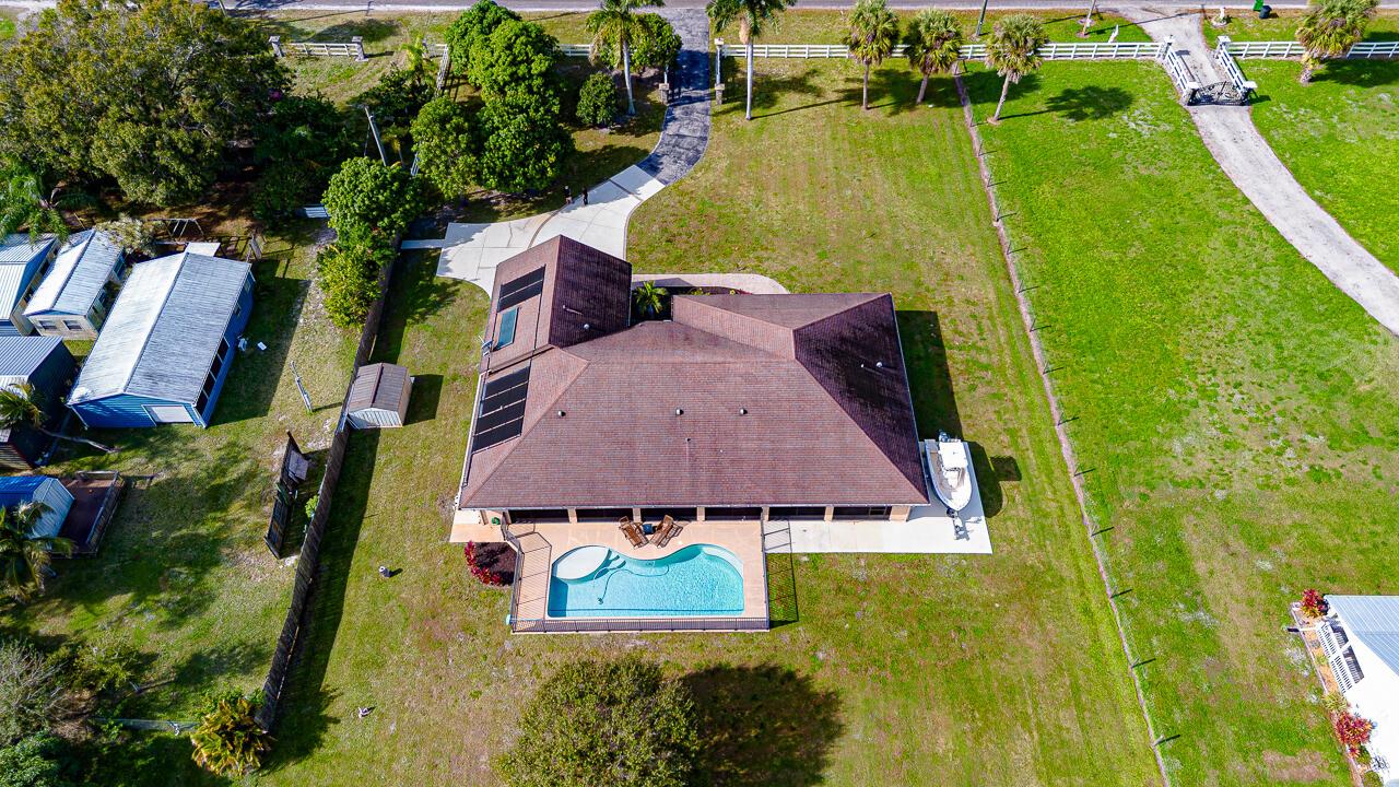 An aerial view shows a house with a swimming pool, solar panels, and a boat — 2774 Gentile Road, Fort Pierce FL 34945, FORT PIERCE, FL