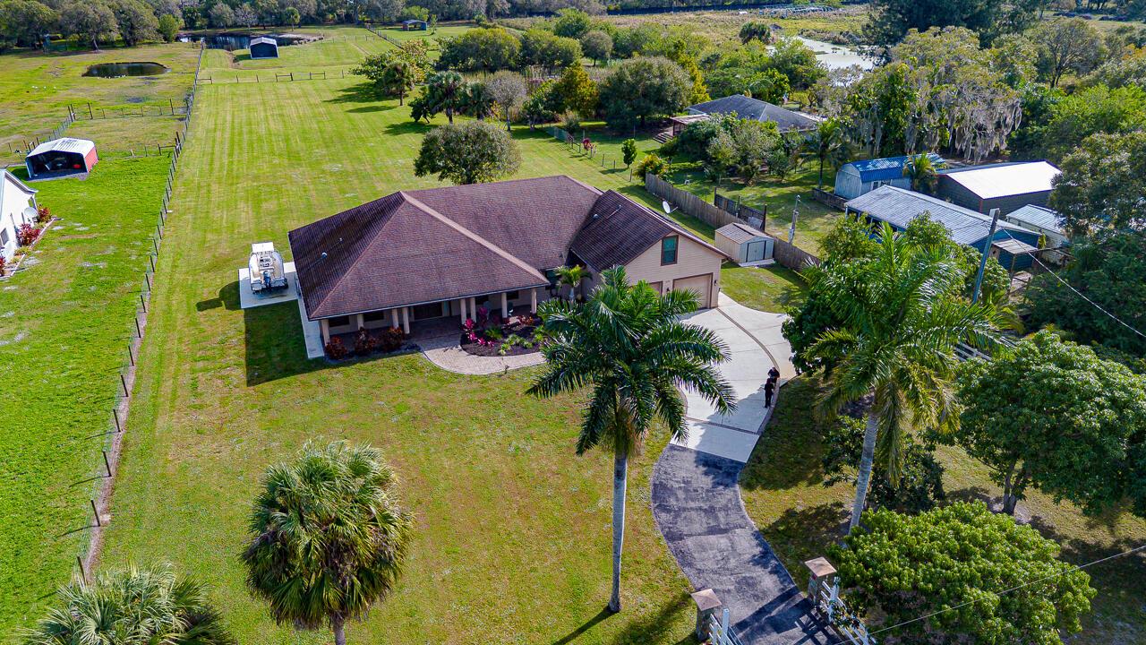 An aerial view of a single-story house with a brown roof and a large yard — 2774 Gentile Road, Fort Pierce FL 34945, FORT PIERCE, FL