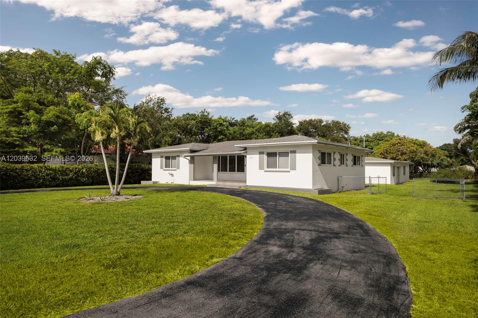 A white single-story house features a curved asphalt driveway and a large grassy lawn — 7840 SW 71st Ave, Miami FL 33143, MIAMI, FL