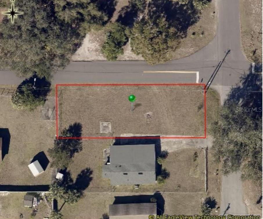 An aerial view shows a rectangular vacant lot outlined in red next to a house — S THOMPSON STREET, DELAND, FL
