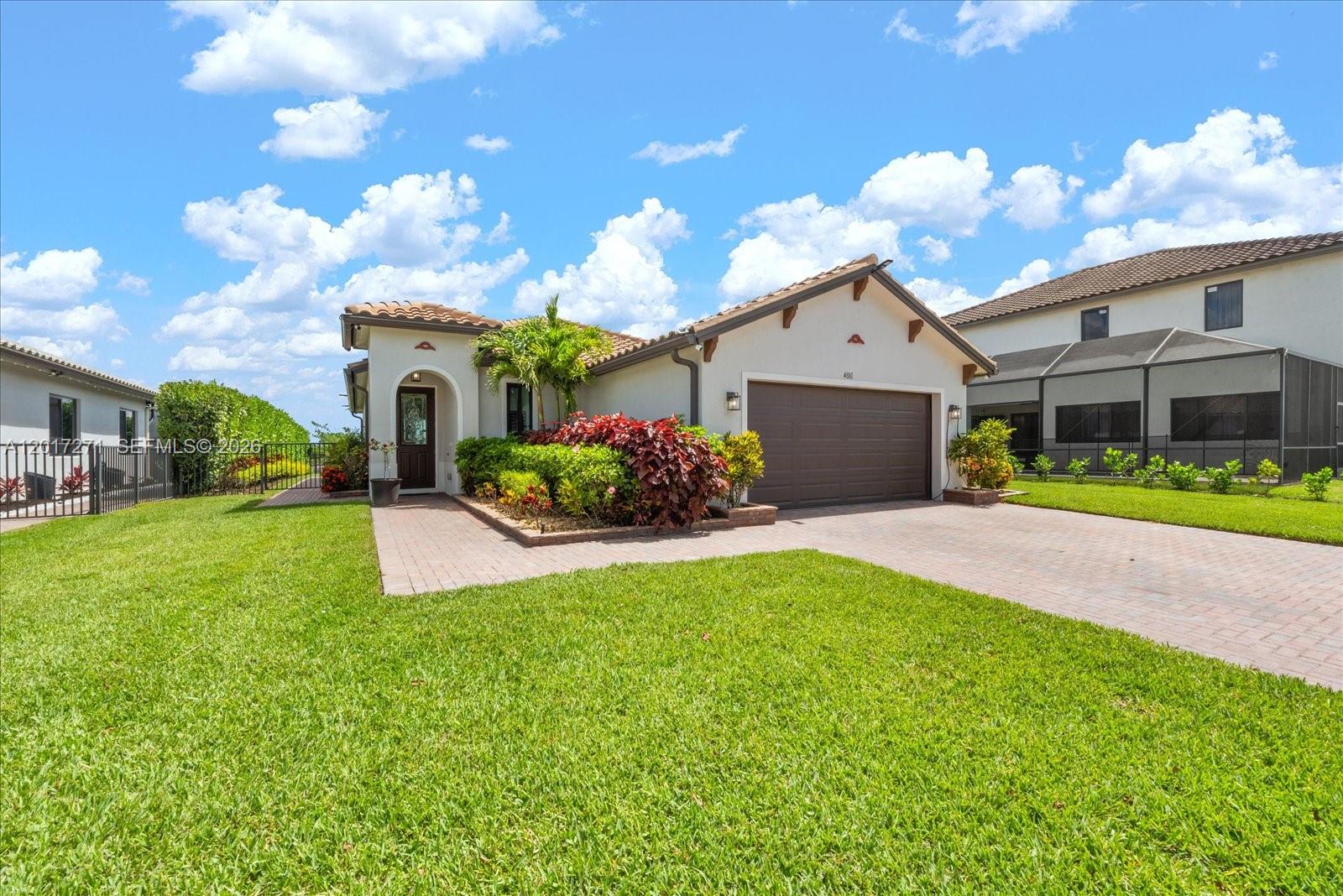 A single-story house with a brown garage door, tiled roof, and a paved driveway — 4881 Iron Horse Way, Ave Maria FL 34142, AVE MARIA, FL