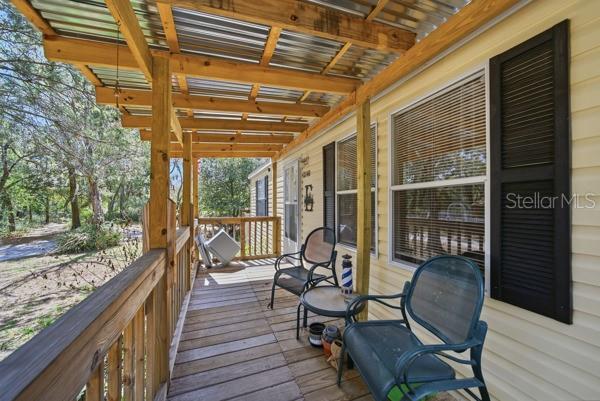 An open-concept living room and kitchen with wood-look flooring and brown leather furniture — 12148 RUTHERFORD LANE, HUDSON, FL