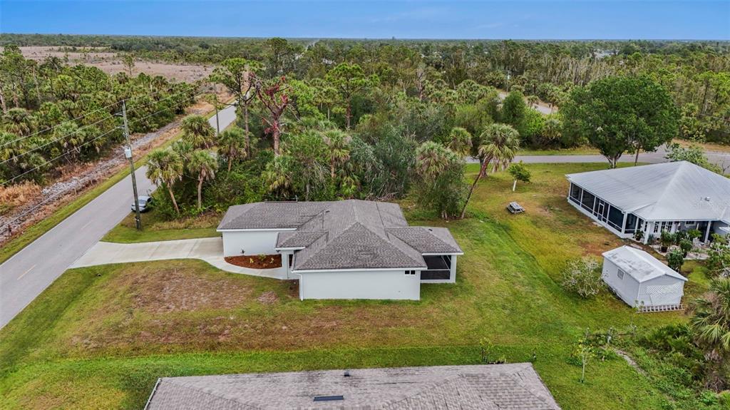 An aerial view shows a single-story house with a gray roof, driveway, and surrounding yard — 5400 JENNINGS BOULEVARD, PORT CHARLOTTE, FL