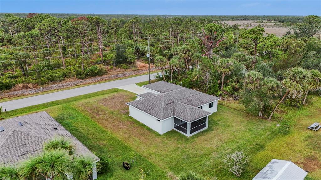 An aerial view shows a single-story house with a screened lanai and a paved driveway — 5400 JENNINGS BOULEVARD, PORT CHARLOTTE, FL