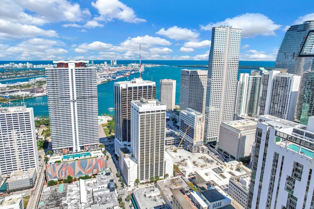 An aerial view of a dense urban skyline featuring high-rise buildings near a waterfront — 1 SE 3rd Ave, Miami FL 33131, MIAMI, FL