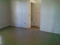An interior view of a room with light-colored paneled walls and tiled flooring — 114 N CHESTER STREET, LEESBURG, FL