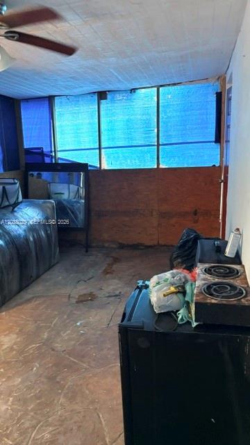 A room with a ceiling fan, a large window covered in blue plastic, and a kitchenette — 6833 SW 20th St, Miramar FL 33023, MIRAMAR, FL
