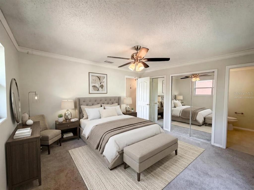 A bedroom features a tufted headboard, a bench, and mirrored closet doors — 505 OAK DRIVE, TAVARES, FL