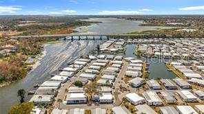An aerial view of a mobile home community situated along a lake and a bridge — 10473 HOLIDAY SHORES DRIVE UNIT 303, LARGO, FL