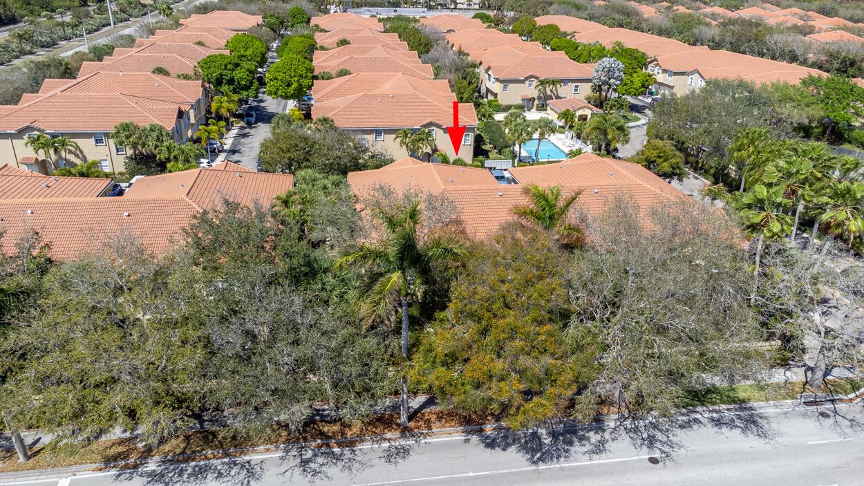 An aerial view shows a residential complex with tile roofs, palm trees, and a pool — 110 Lighthouse Circle # H, Tequesta FL 33469, TEQUESTA, FL