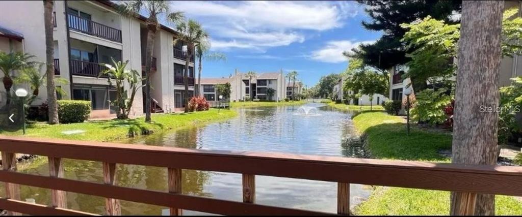 A view from a wooden bridge overlooking a pond between multi-story apartment buildings — 3850 N LAKE DRIVE UNIT 140, TAMPA, FL