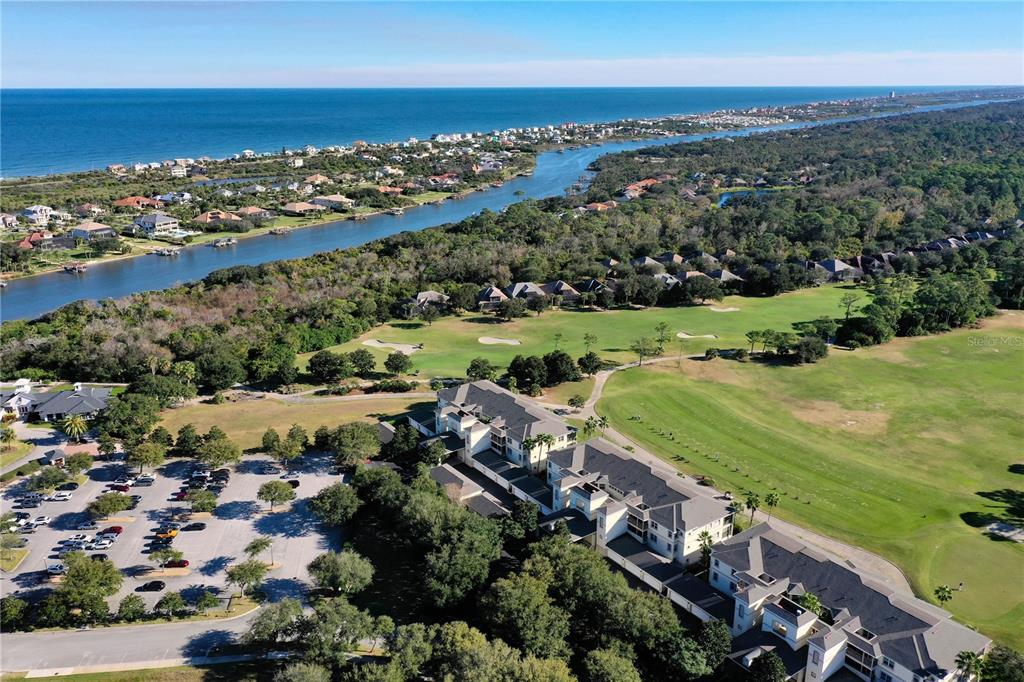 An aerial view shows a large apartment complex adjacent to a golf course and waterway — 200 RIVERFRONT DRIVE UNIT D304, PALM COAST, FL