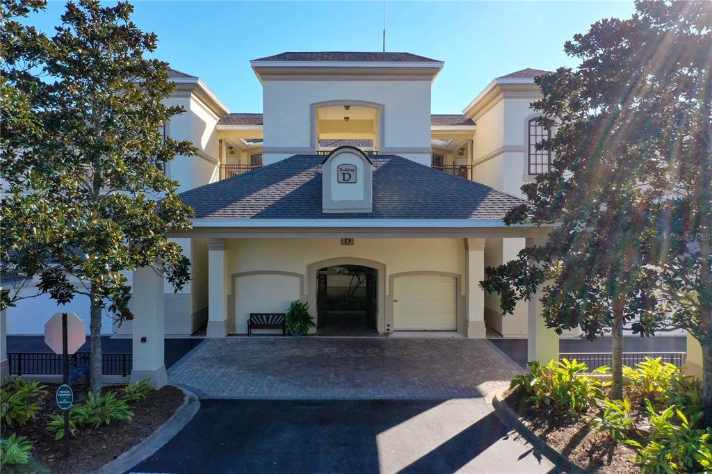 A two-story building exterior features a covered entrance with a brick driveway and columns — 200 RIVERFRONT DRIVE UNIT D304, PALM COAST, FL