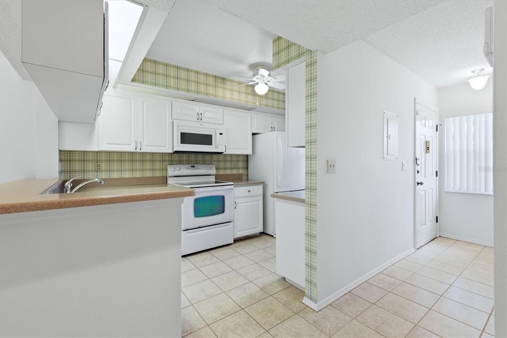 A living room features two floral sofas, two armchairs, a coffee table, and a floor lamp — 421 CERROMAR TERRACE UNIT 370, VENICE, FL