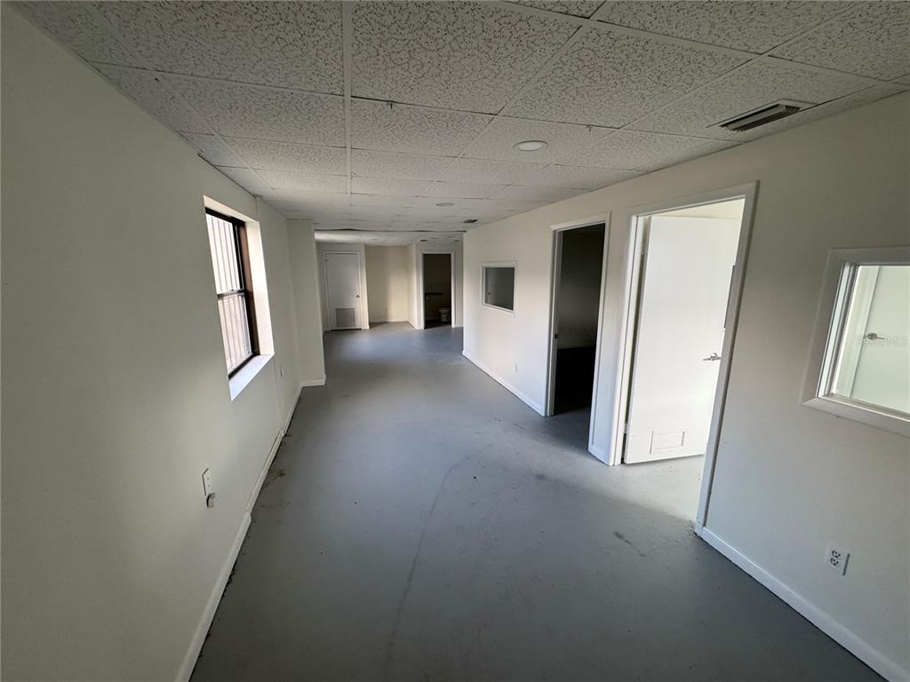 An interior view of a commercial office space with white walls, grey flooring, and drop ceilings — 702 W PARK AVENUE UNIT A1, EDGEWATER, FL