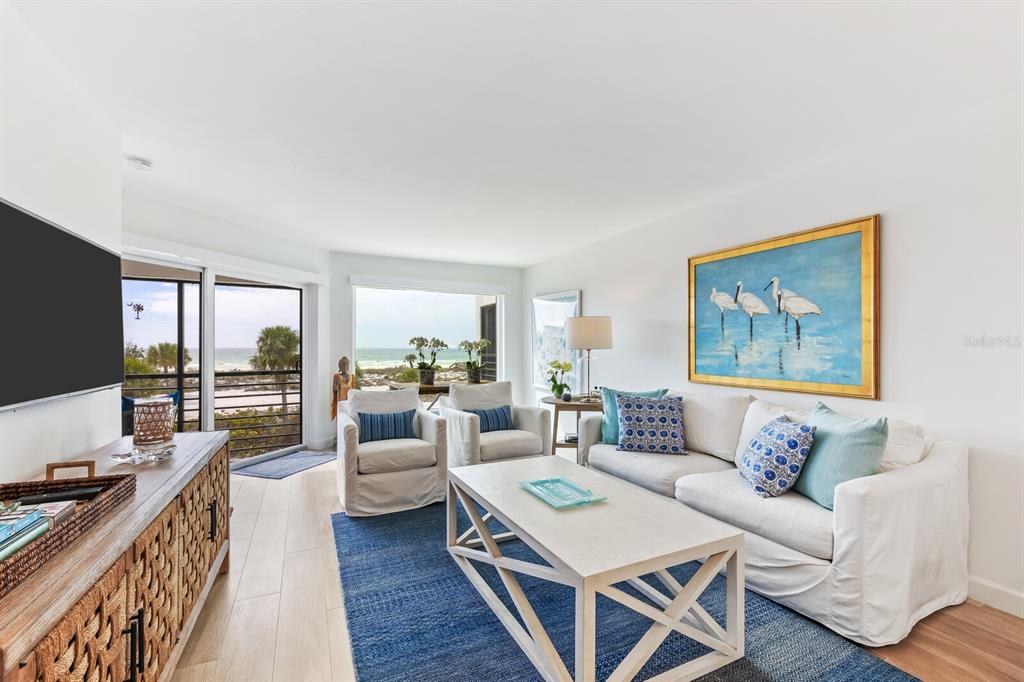A living room features a white sofa, two armchairs, a coffee table, and ocean views — 5000 GASPARILLA ROAD UNIT BC202, BOCA GRANDE, FL