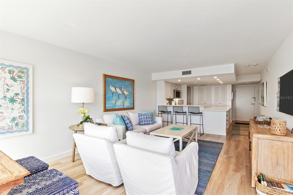 A living room with white furniture, a blue rug, and an open kitchen with bar seating — 5000 GASPARILLA ROAD UNIT BC202, BOCA GRANDE, FL