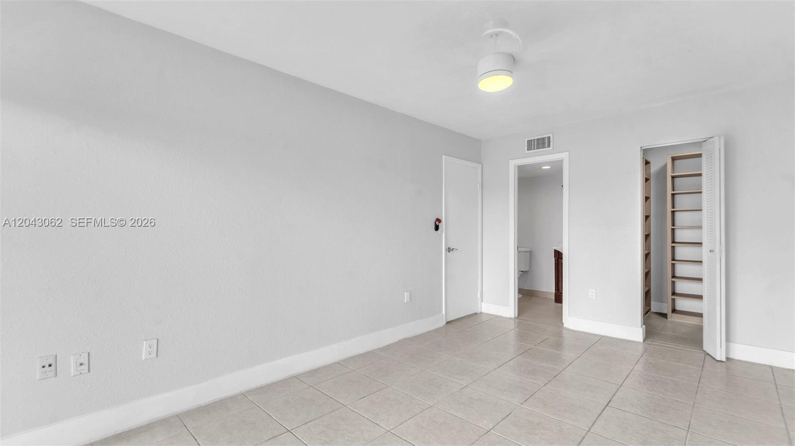 A room with light gray walls, tiled flooring, a ceiling light, and two open doorways — 10755 SW 108th Ave # 304, Miami FL 33176, MIAMI, FL