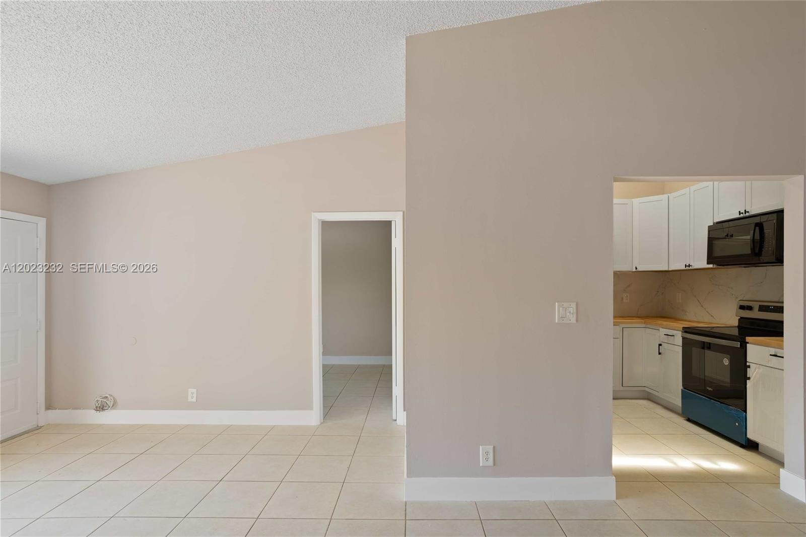 A kitchen features white cabinets, a wood countertop, black appliances, and a marble-patterned backsplash — 3633 NW 99th Ter # 7B, Sunrise FL 33351, SUNRISE, FL