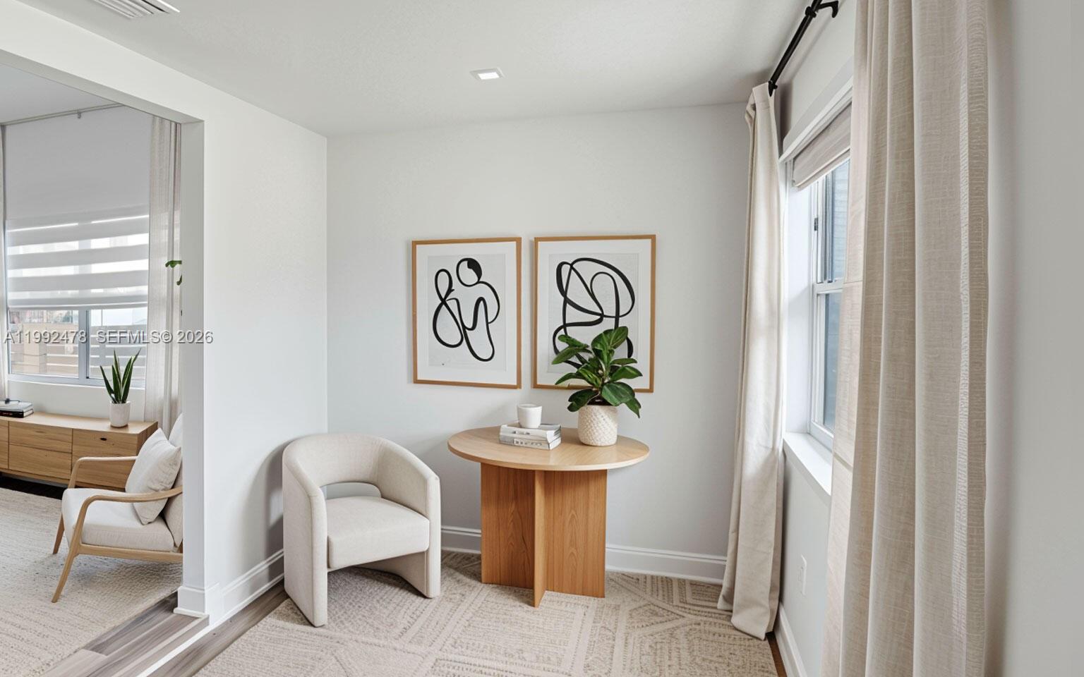 A small sitting area features a round wooden table, an armchair, and two framed prints — 2135 SW 4th St, Miami FL 33135, MIAMI, FL