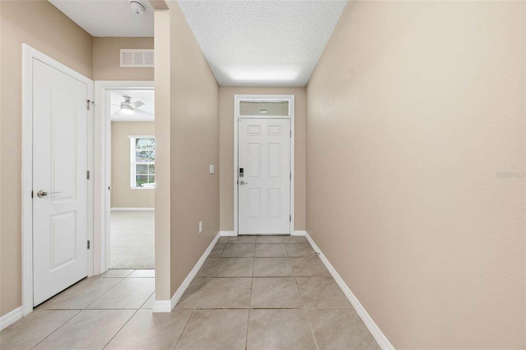 A tiled entryway leads to a white front door with a transom window above — 600 TALISI LOOP, ST CLOUD, FL