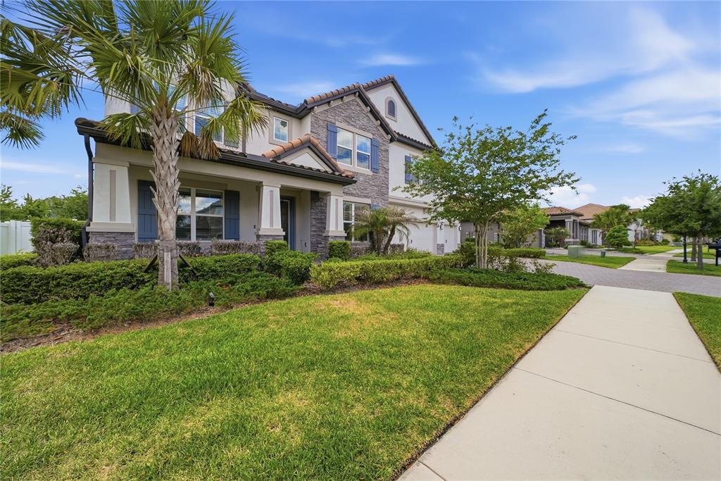 A two-story house with stone veneer, blue shutters, and a front porch — 33260 KATELAND DRIVE, WESLEY CHAPEL, FL