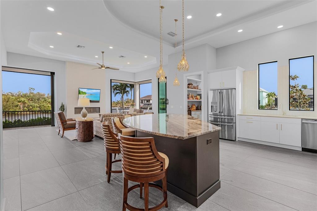 An open-concept kitchen and living area with a large island, stainless appliances, and water views — 1729 NW 41ST AVENUE, CAPE CORAL, FL