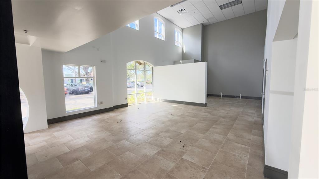 An empty commercial space with high ceilings, large windows, and light-colored tile flooring — 8803 FUTURES DRIVE UNIT 3, ORLANDO, FL