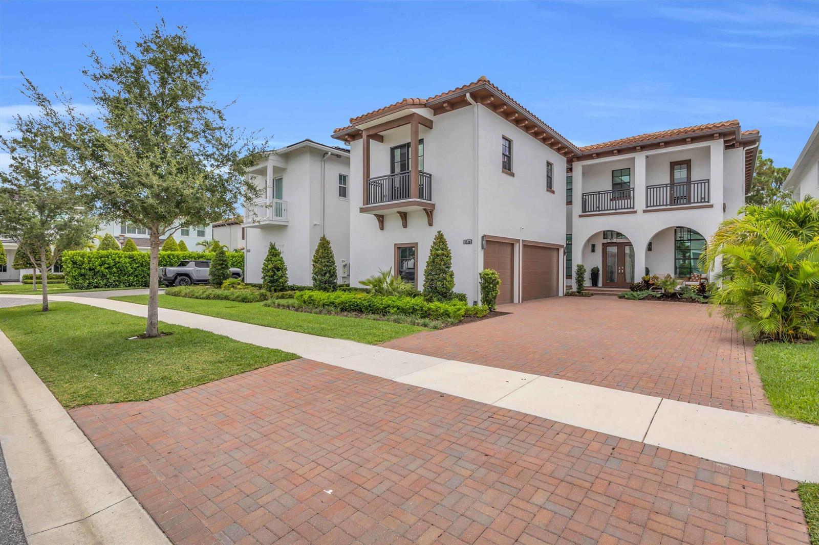 A two-story white stucco house with a tile roof, brick driveway, and attached garage — 13372 Bernoulli Way, Palm Beach Gardens FL 33418, PALM BEACH GARDENS, FL