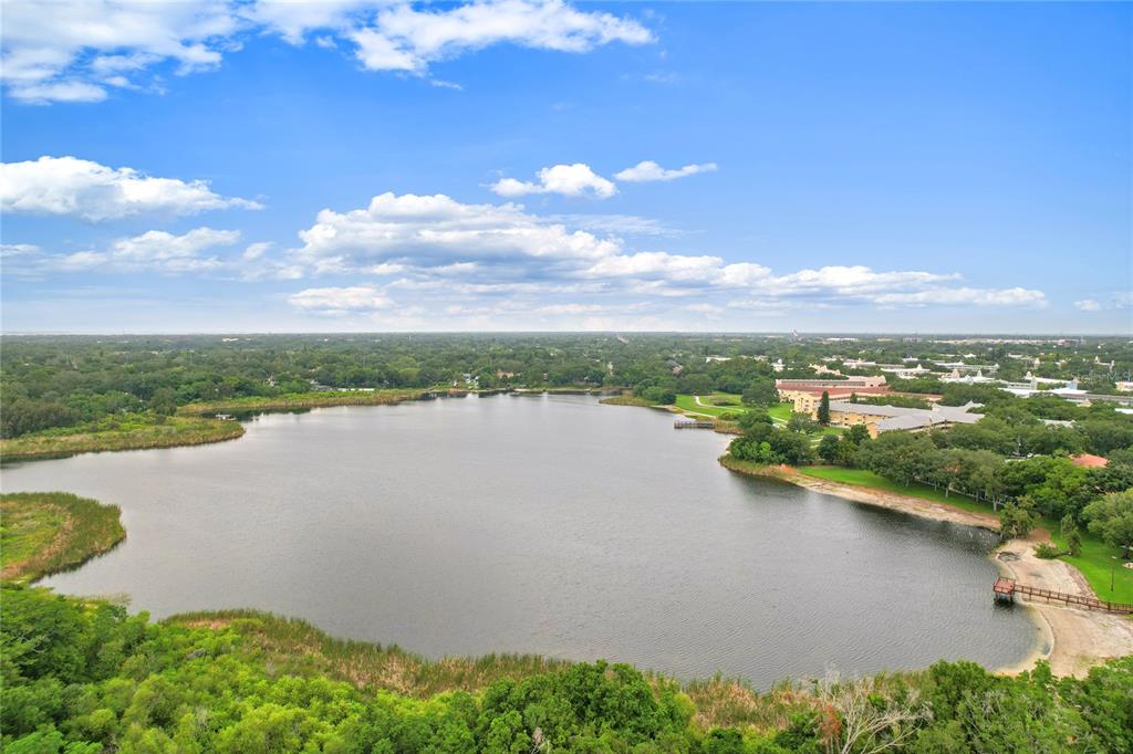 An aerial view of a lake surrounded by trees and a multi-story building complex — 2209 UTOPIAN DRIVE E UNIT 307, CLEARWATER, FL